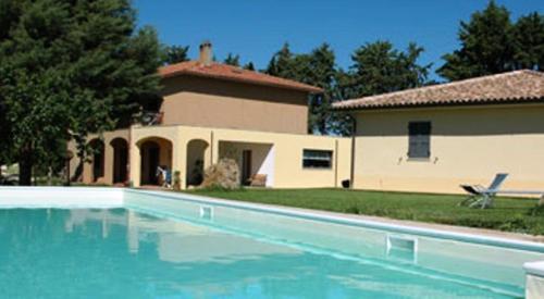 une grande piscine en face d'une maison dans l'établissement Agriturismo Cavallin Del Bufalo, à Manciano