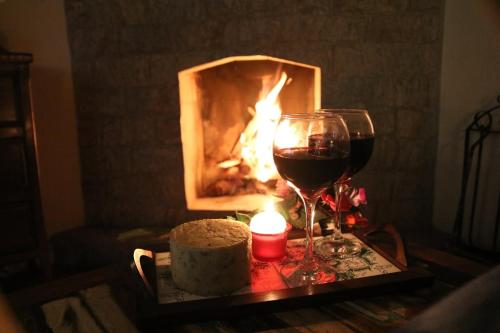 a table with a cake and a glass of wine at Chalés das Orquídeas in Visconde De Maua