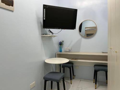 a room with a table and two stools and a tv on the wall at Quirino Hub (402-c) in Davao City