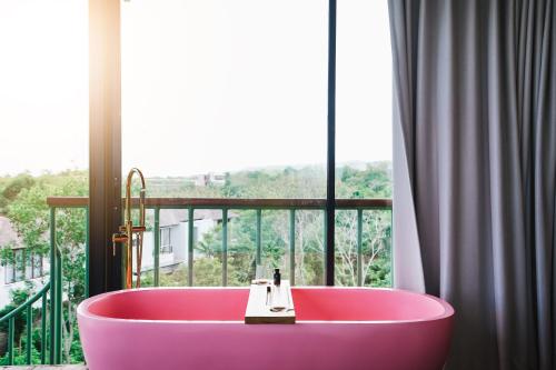 a pink bath tub in front of a window at Salty Breeze Bali in Ungasan
