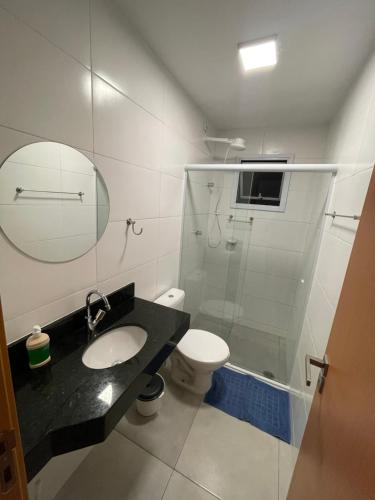 a bathroom with a sink and a toilet and a mirror at Apê212 - 650m da Orla in Ubatuba