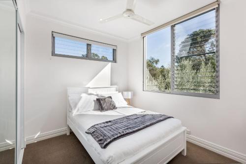 Un dormitorio blanco con una cama y dos ventanas. en Beach Life on Beach, en Dunsborough
