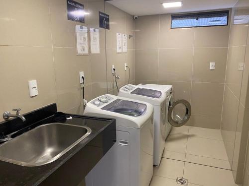 y baño con lavadora y lavamanos. en Nomar X - Lindo Apartamento à 50MTS mar, en João Pessoa