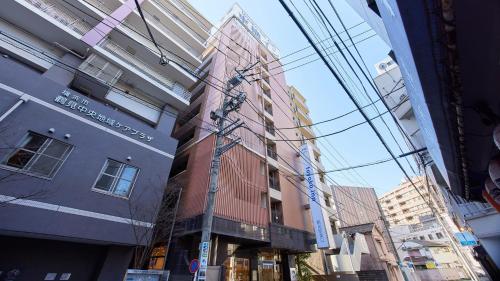 a tall red building in the middle of a city at Toyoko Inn Yokohama Tsurumi eki Higashi guchi in Yokohama