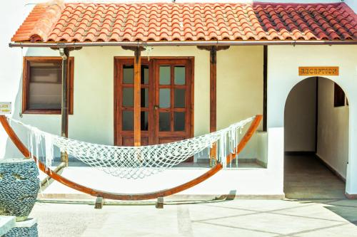 a hammock in front of a house at Xenios Possidi Paradise Hotel in Possidi