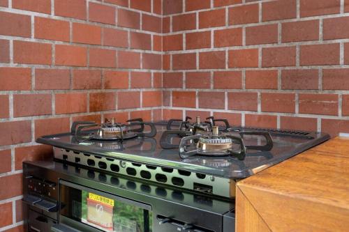 a stove top oven sitting next to a brick wall at S-villa Nasu Audrey in Nasu