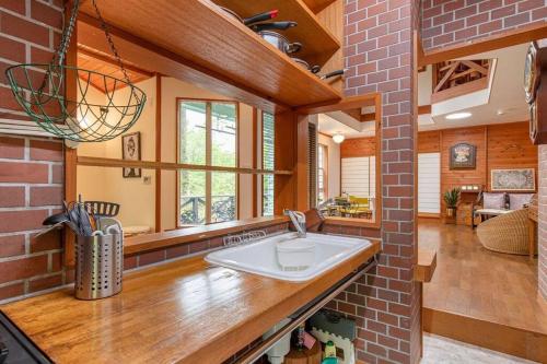 a kitchen with a sink and a brick wall at S-villa Nasu Audrey in Nasu