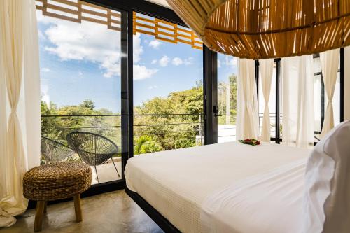 a bedroom with a bed and a large window at L'Avventura Boutique Hotel in Tamarindo