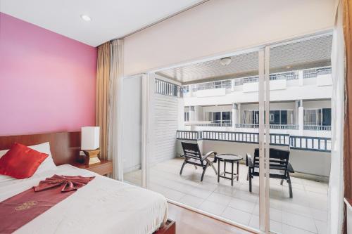 a bedroom with a bed and a table and chairs at Chateau Dale Boutique Resort Spa Villas in Pattaya South