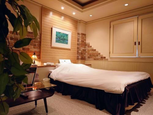 a bedroom with a bed and a desk with a laptop at hotel due in Ogaki