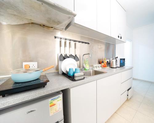 a kitchen with white cabinets and a counter top at Shared dormitory Wan Chai Road 187 in Hong Kong