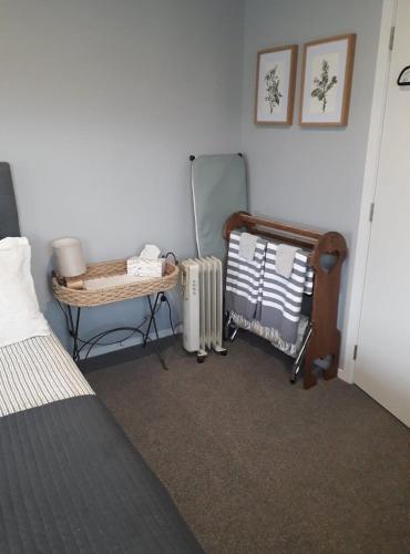 a bedroom with a bed and a mirror and a radiator at Rural Gordonton Sleepout in Hamilton