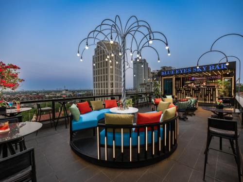 a rooftop patio with a couch and tables and chairs at Shining Central Hotel & Spa in Hanoi