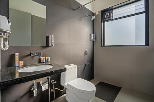 uma casa de banho com um WC, um lavatório e uma janela em Casa Boho by StayVista - Contemporary design, Farm-view, Swimming pool & Indoor games for a chic retreat em Nashik