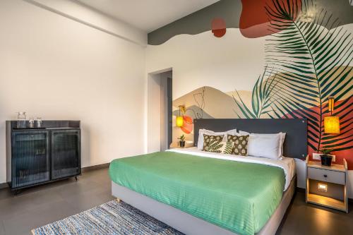 um quarto com uma cama verde e um quadro na parede em Casa Boho by StayVista - Contemporary design, Farm-view, Swimming pool & Indoor games for a chic retreat em Nashik