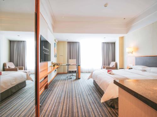 a hotel room with two beds and a desk at Ramada Plaza Shanghai Pudong Airport - 3 mins to PVG depature floor & check entrance with hotel shuttle in Shanghai