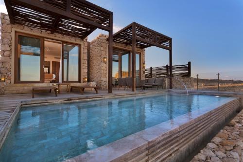 a house with a swimming pool in front of a house at Beresheet by Isrotel Exclusive in Mitzpe Ramon