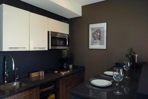 una cucina con lavandino e bancone con bicchieri da vino di Condesa Luxury Lofts 1510 a Città del Messico