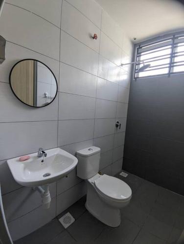 a bathroom with a toilet and a sink and a mirror at Cikgu I&S Homestay in Jitra