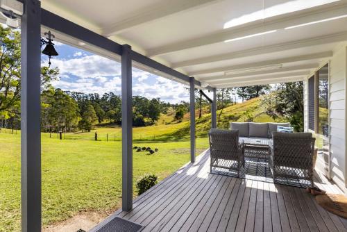een terras met een tafel en stoelen op een dek bij Fiery, cozy starry nights - Farm stay! in Bellthorpe