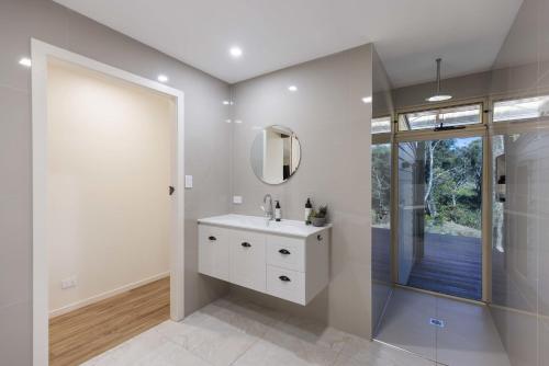 a bathroom with a sink and a mirror and a shower at Fiery, cozy starry nights - Farm stay! in Bellthorpe