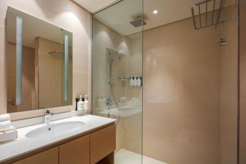 a bathroom with a sink and a shower at Holiday Inn & Suites - Dubai Science Park by IHG in Dubai