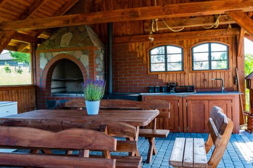 a kitchen with a wooden table and a stone oven at Domki Nad Stawem Mazury in Mrągowo