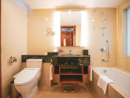 a bathroom with a toilet and a sink and a tub at Ramada Plaza Shanghai Pudong Airport - 3 mins to PVG depature floor & check entrance with hotel shuttle in Shanghai