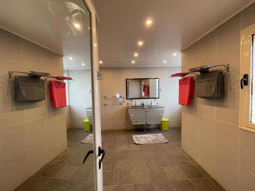 a bathroom with a shower with a sink and a tub at Villa vue sur mer in El Djamila