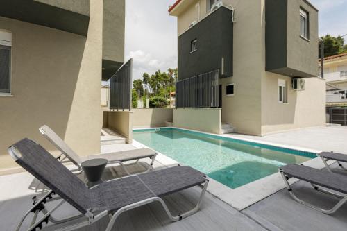 a patio with chairs and a swimming pool at V Luxury Apartments with Pool in Siviri
