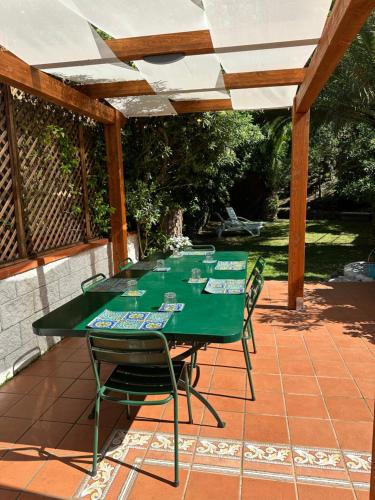 une table et des chaises vertes sur la terrasse dans l'établissement Villa la caletta, à Maiori