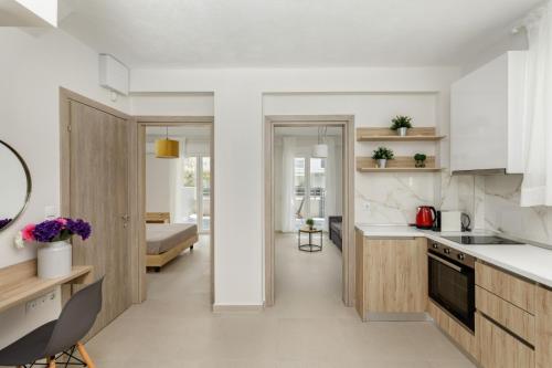 uma cozinha com bancadas brancas e armários de madeira em V Luxury Apartments with Pool em Siviri