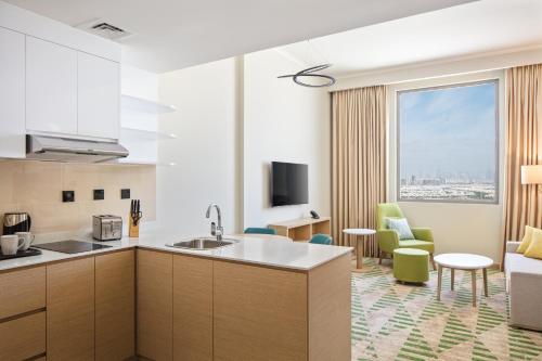 Holiday Inn & Suites - Dubai Science Park, an IHG Hotel في دبي: مطبخ وغرفة معيشة مع نافذة كبيرة