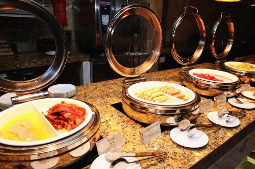 a buffet with plates of food on a counter at Ramada Plaza Shanghai Pudong Airport - A journey starts at the PVG Airport in Shanghai