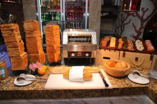 a counter top with bread and a cutting board with at Ramada Plaza Shanghai Pudong Airport - A journey starts at the PVG Airport in Shanghai