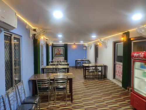 a restaurant with tables and chairs in a room at Heritage Bagala Dharmasala in Puri