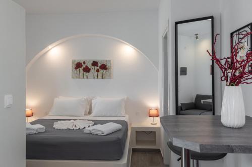 a bedroom with a bed and a table and a mirror at Sunset Village 4 in Paleochori
