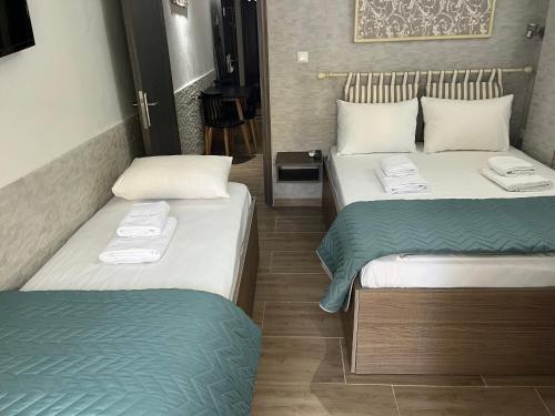 Dos camas en una habitación de hotel con toallas. en Grecian Sea, en Limenaria