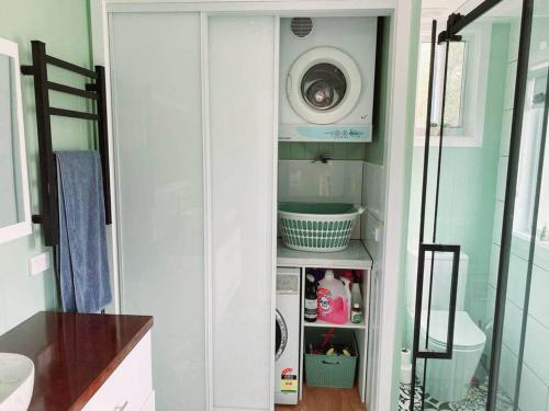 a bathroom with a washer and dryer in a room at Blue Bay View Surf & Sauna Stay in Surf Beach