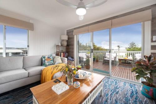 a living room with a couch and a table at Blue Bay View Surf & Sauna Stay in Surf Beach
