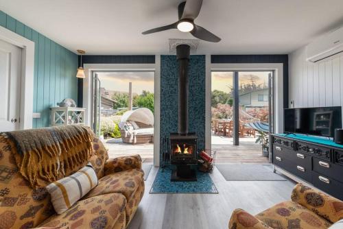 a living room with a couch and a fireplace at Blue Bay View Surf & Sauna Stay in Surf Beach