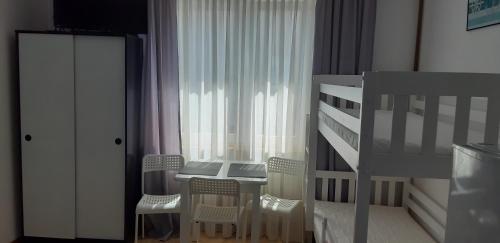a bedroom with a table and chairs and a bed at Pokoje Gościnne Galeon w Darłówku in Darłowo