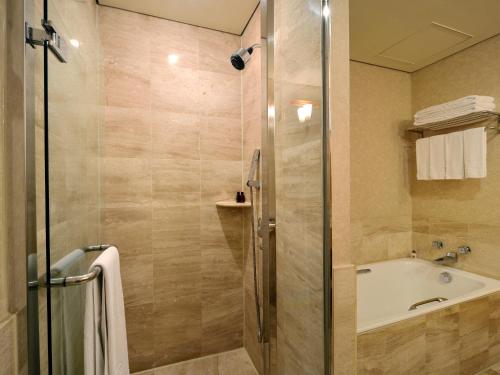 a bathroom with a shower and a tub and a sink at THE LEES Hotel in Kaohsiung