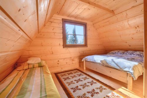 Dormitorio de una cabaña de madera con cama y ventana en Osada Pod Turbaczem, en Nowy Targ