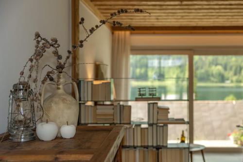 una habitación con una mesa con un jarrón y algunos libros en Haus Sonnbichl, en Weissensee