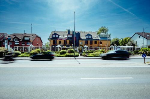 Une rue avec des voitures qui descendent dans une rue avec des maisons dans l'établissement Design Hotel Euskirchen, à Euskirchen