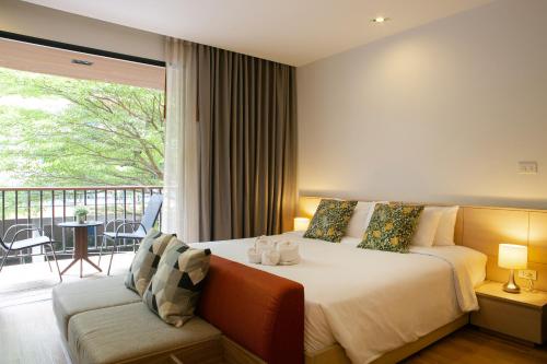 1 dormitorio con 1 cama y balcón en The Silver Palm Wellness Resort, en Bangkok