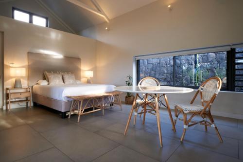 sypialnia z łóżkiem, stołem i krzesłami w obiekcie Peaceful Tree Cottage w mieście Tamarin