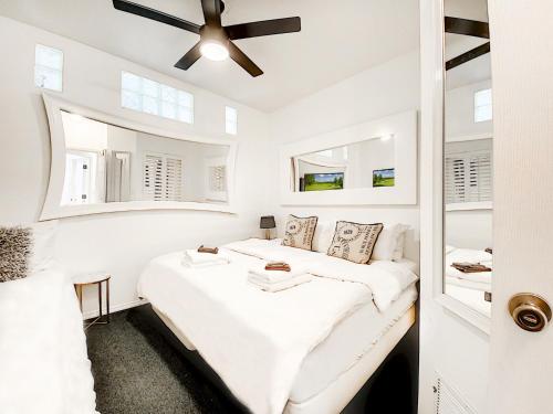Habitación blanca con 2 camas y ventilador de techo. en 7 Room PgaVillageResort by AmericanVacationliving, en Port Saint Lucie