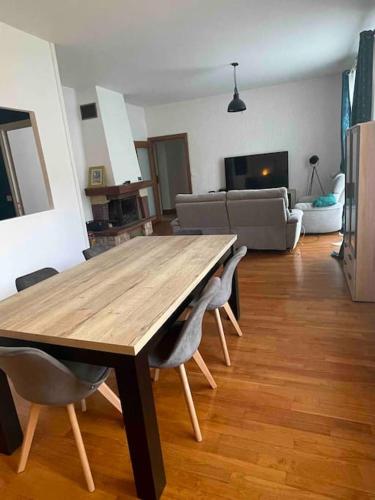 a wooden table and chairs in a living room at Manornella, beaux volumes, grand garage idéal Mas du Clos in Aubusson